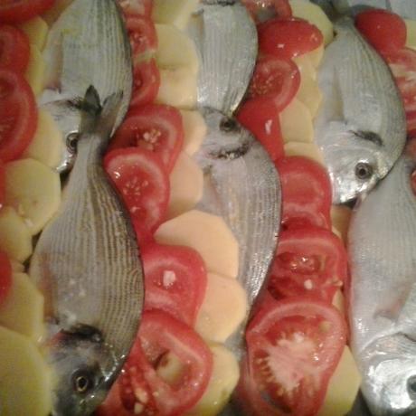 Sea breams, potatoes and tomatoes tray